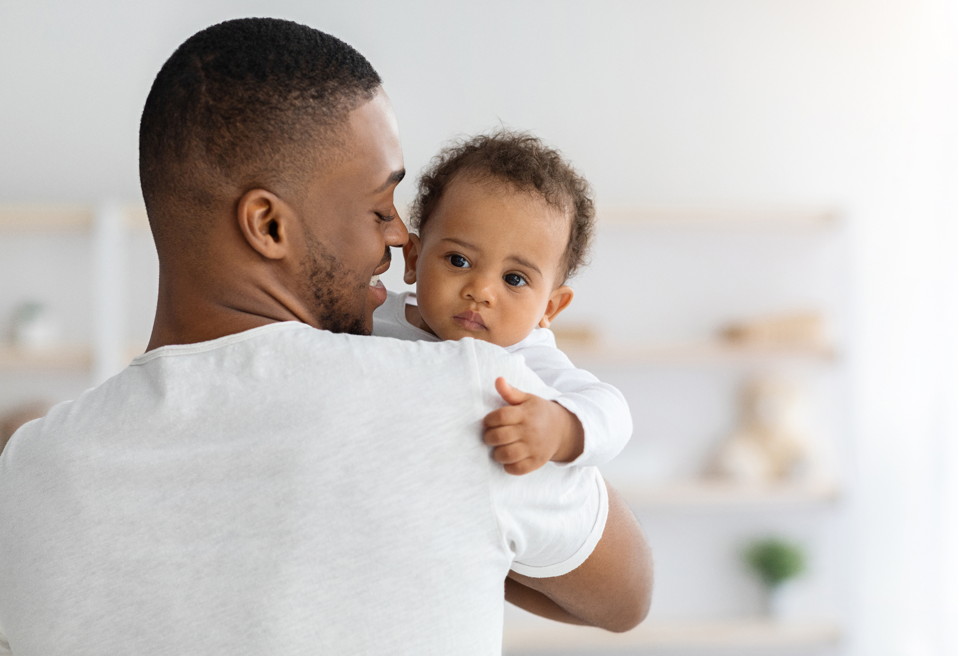 Father smiling with curly-haired baby